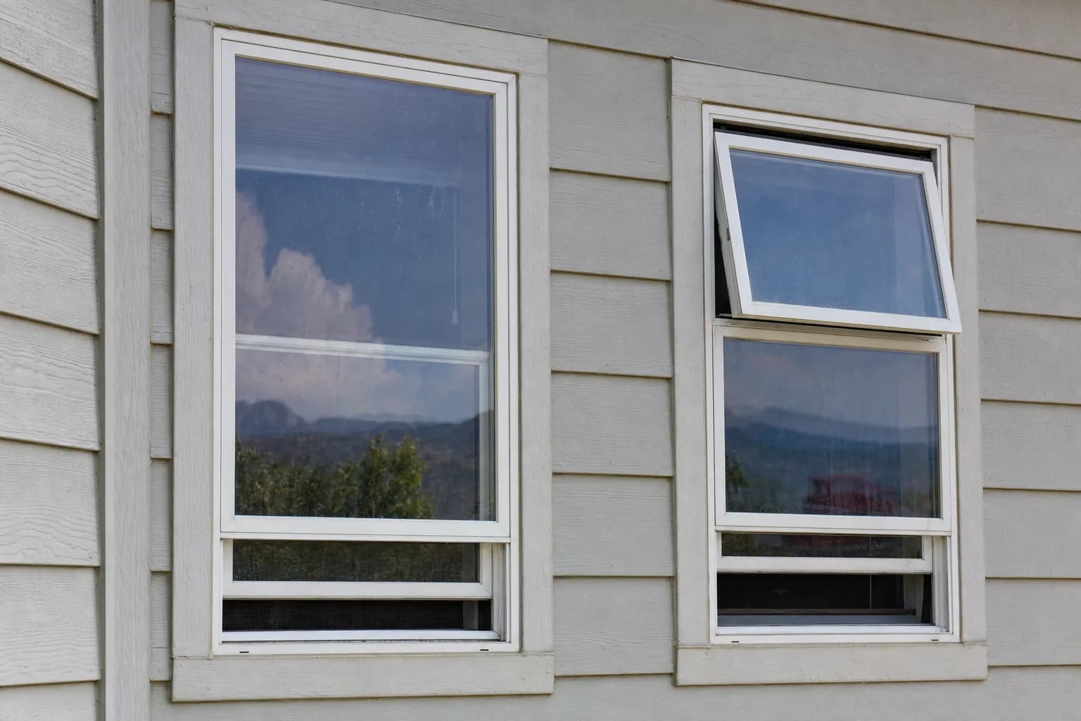 Side-by-side comparison of a single hung window and a double hung window on a home exterior, showing the difference in sash operation