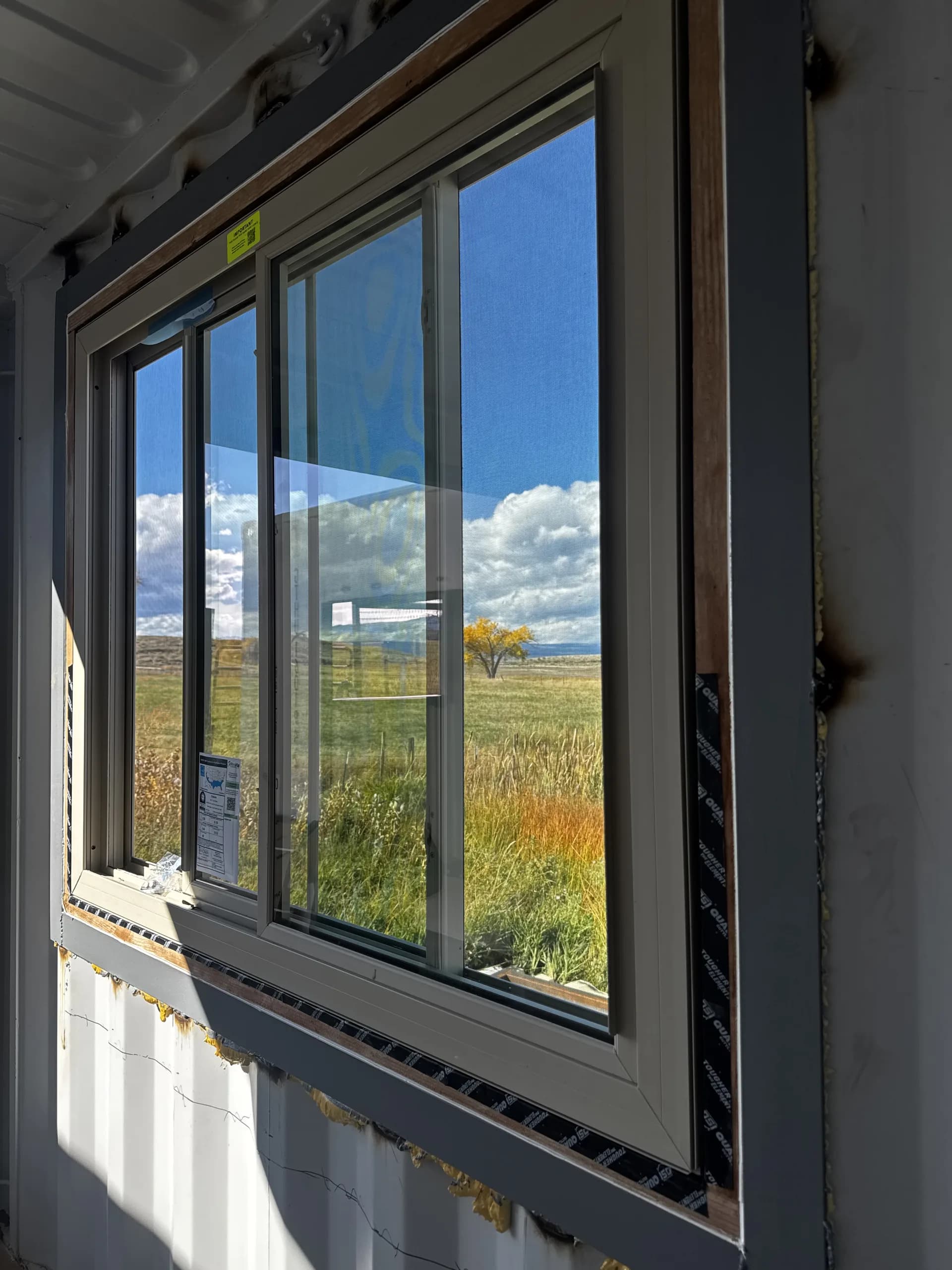 Black-framed casement windows on a home exterior, open to the outdoors