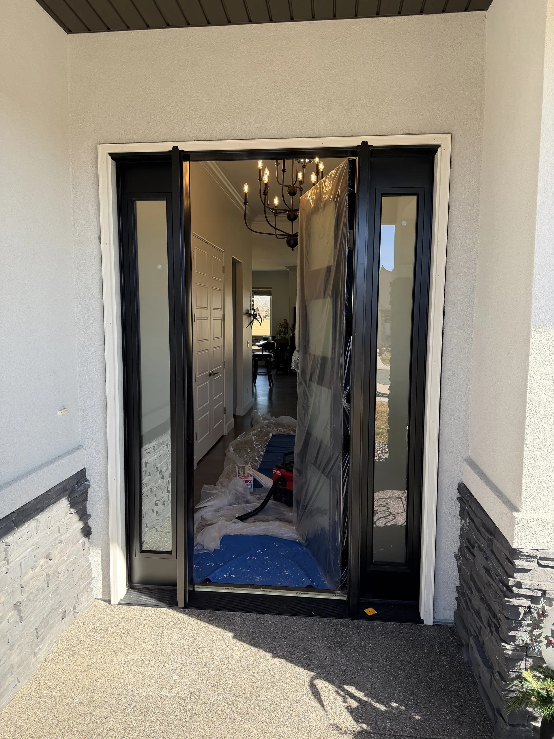 Modern black entry door with sidelights in a bright foyer, Montrose CO home