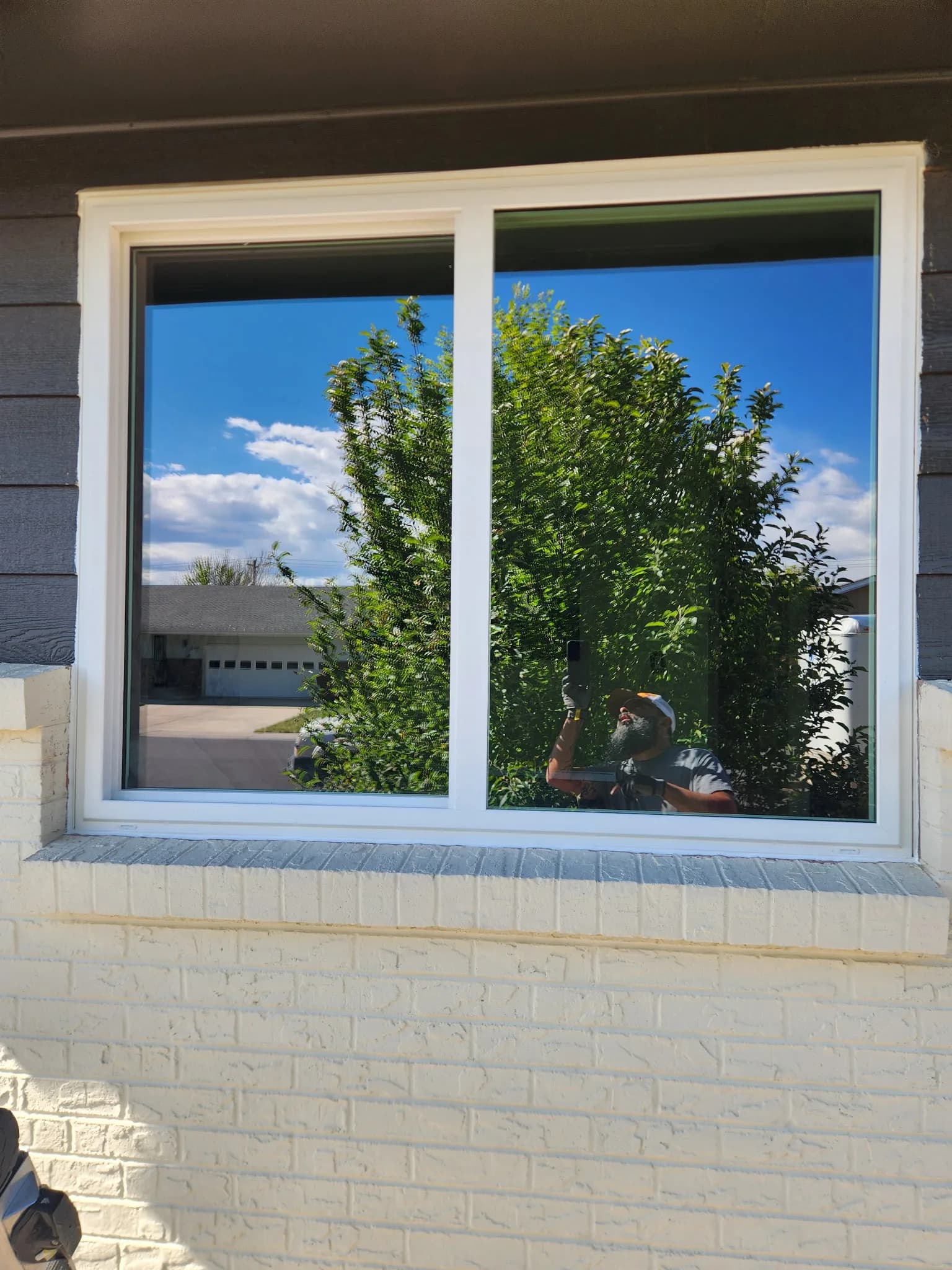 Vinyl slider window against a bright blue Colorado sky