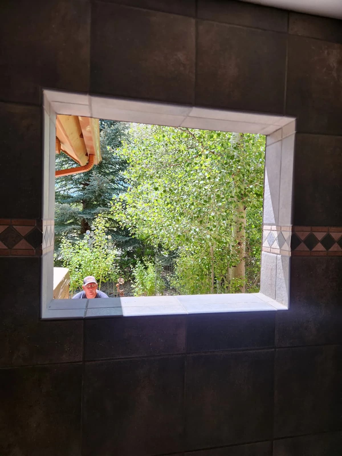 Wood-framed bay window looking out onto lush greenery